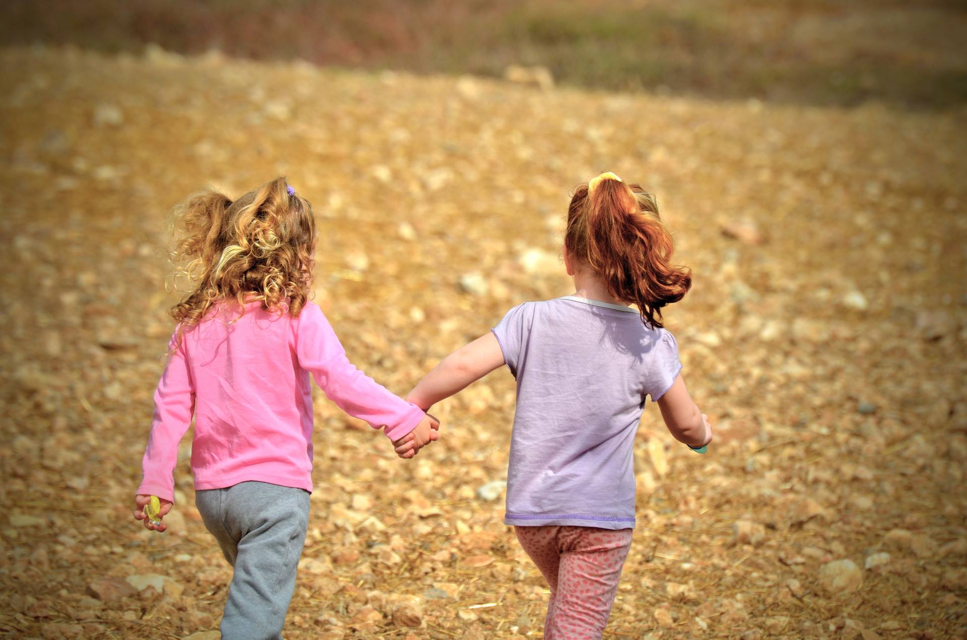 Two girls holding hands and walking together Two girls holding hands and walking together